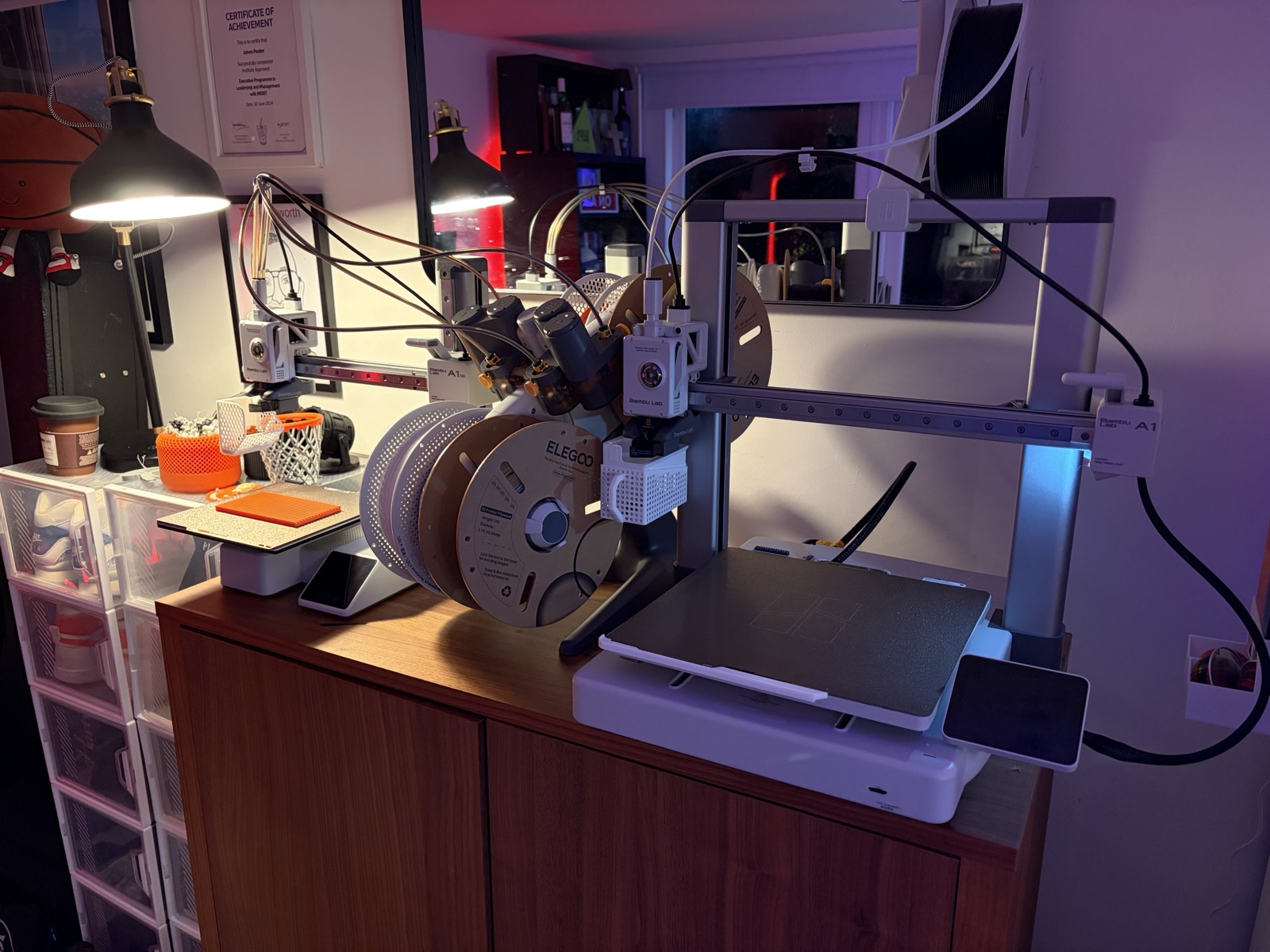 Bambu Lab A1 3D printer with Elegoo filament spools on wooden cabinet