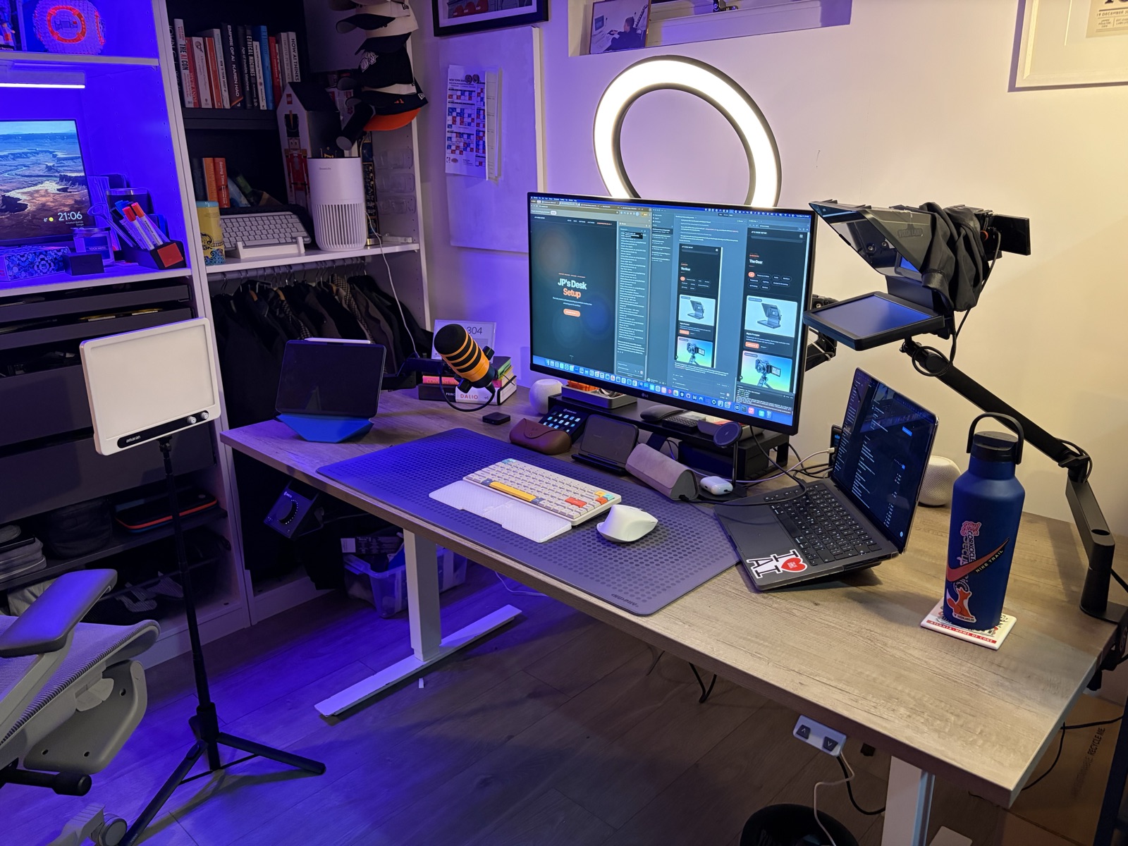 Wide angle view of the complete workspace with standing desk, shelving, and ambient lighting